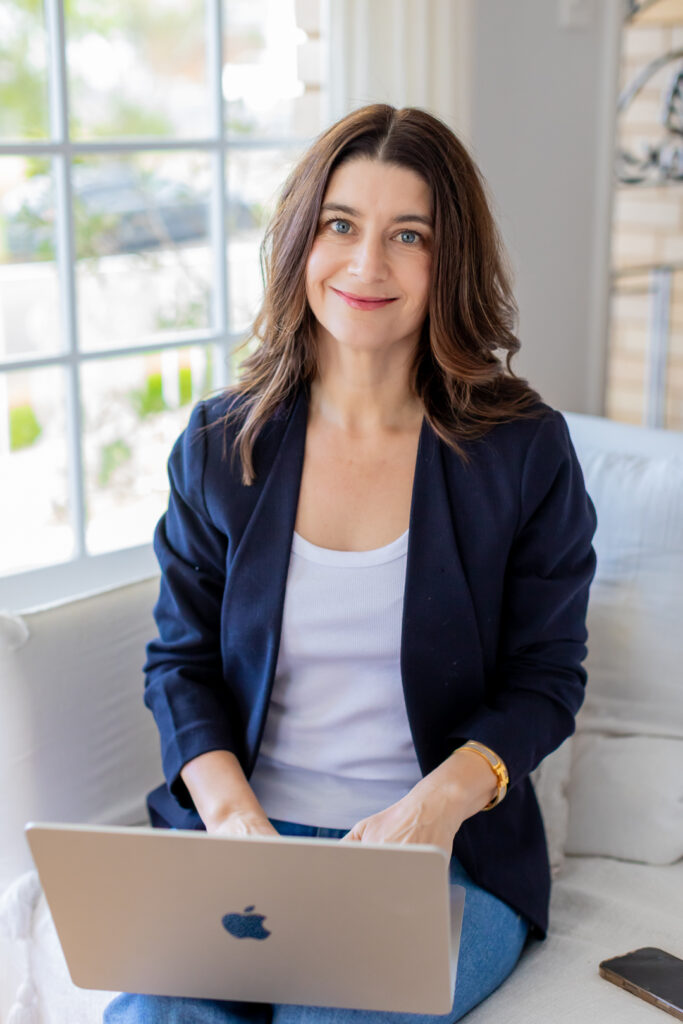 Girl on couch with laptop smiling at camera